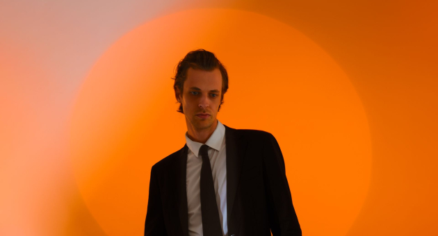 David Linszen in pak voor een oranje achtergrond
