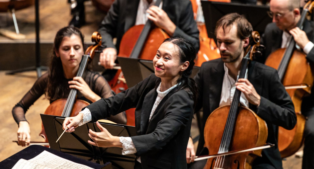 Vrouwelijke dirigent voor een orkest met cellisten
