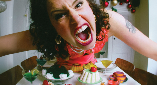 Boze vrouw buigt zich schreeuwend over dinertafel