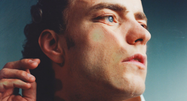 Man kijkt opzij met handen tegen glasoppervlak