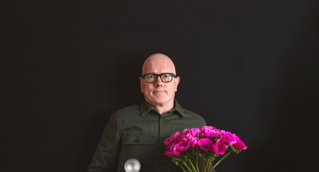 Kees van Amstel met een bosje bloemen in zijn hand 