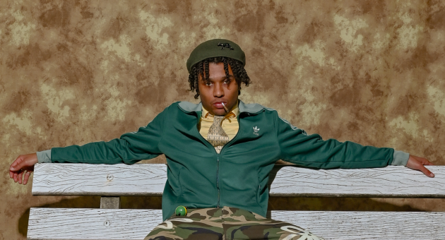 Man in sportjack en camobroek op witte bank