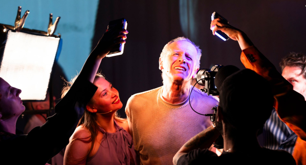 Een man staat in het midden en wordt belicht met felle lampen.