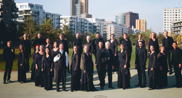 Koor in formele concertkleding poseert in een stadspark