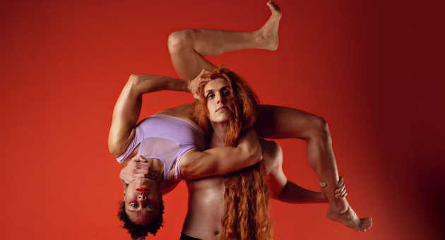 Duo van mensen waarbij de ene persoon de andere opgetild heeft in een bijzonder houding.