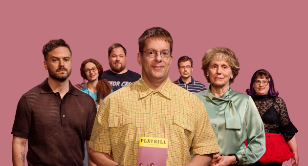 Groep van zeven mensen poseert voor een roze achtergrond; de man in het midden houdt een boek vast.