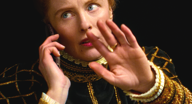 Vrouw in renaissancekleding belt en maakt afwerend gebaar met hand.