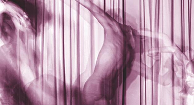 Abstracte, paars getinte foto van een dansende figuur achter doorschijnende gordijnen, met vloeiende bewegingen en vervaagde contouren.