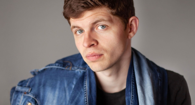 Thjum Arts poserend in een spijkerjas