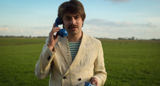 Joost Oomen met blauwe telefoon in weiland