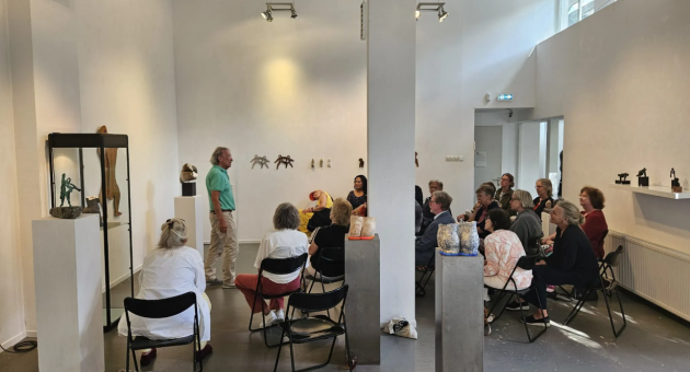 Paul de Mol in gesprek met het publiek tussen sculpturen 