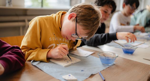 Kind schildert Delfts Blauwe tegel bij atelier