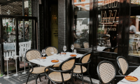Een sfeervol terras bij Old Jazz, met gedekte tafels, rieten stoelen en een uitnodigende uitstraling, perfect voor een gezellige eetervaring.