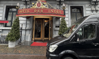 Luxe Mercedes Sprinter bus van DG Luxury tours voor de deur van Hotel Des Indes in Den Haag