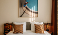 Deluxe Double Room met een bed met daarop kussens en warme houten accenten