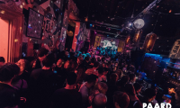Drukke dansvloer in het Paardcafé in Den Haag, met feestende mensen, kleurrijke verlichting en een levendige sfeer.