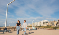Zwei junge Leute spazieren an der Promenade von Scheveningen.