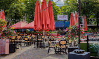 Terras buiten op het Plein van Restaurant Luden met rode parasols