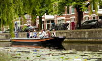 Een sloep vaart in een gracht in Den Haag