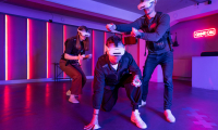 Amaze VR. Drei Personen interagieren mit virtueller Realität in einem bunten Raum.