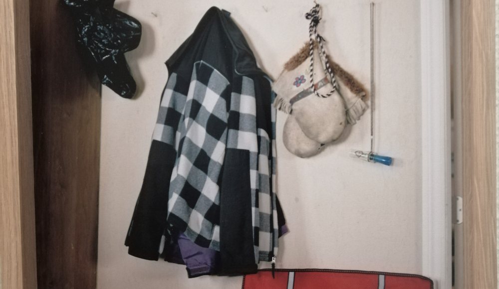 Houhakkersvest en handschoenen aan de muur in blokhut Houhakkersvest en handschoenen aan de muur in blokhut