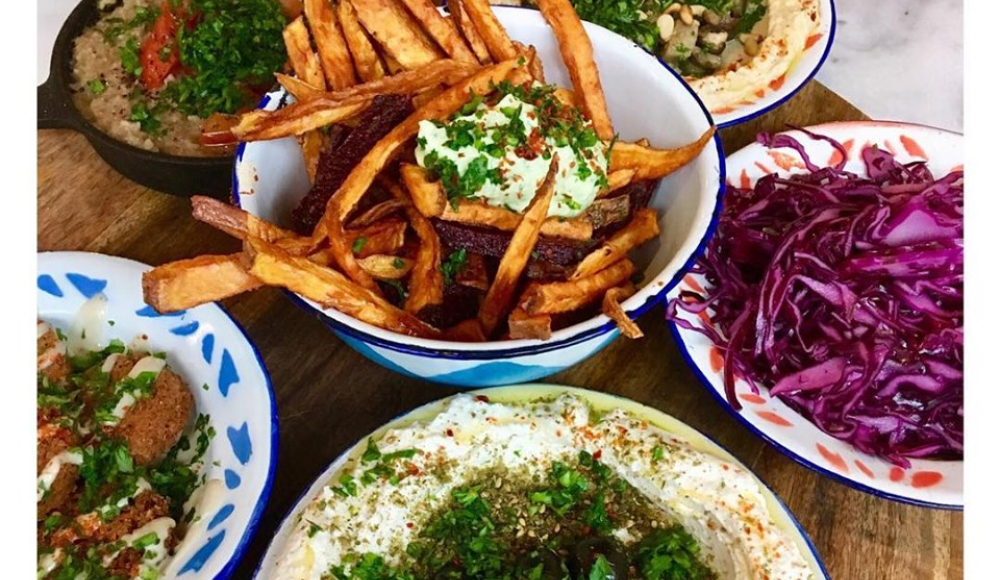 Tafel vol kleurrijke vegetarische gerechten van Hummus in het Zeeheldenkwartier Tafel vol kleurrijke vegetarische gerechten van Hummus in het Zeeheldenkwartier