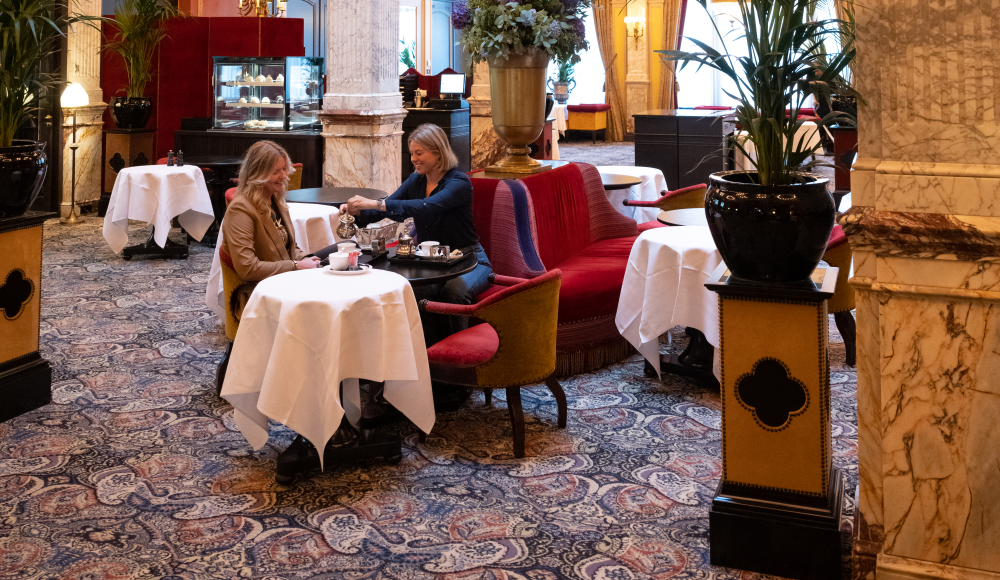 Twee dames die van een high tea genieten in prachtig en rijk historische hotel Des Indes