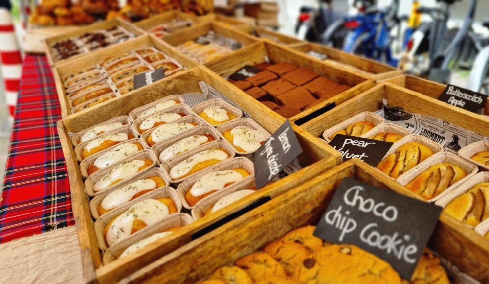Een marktkraam met koekjes, cake en nog meer lekkers