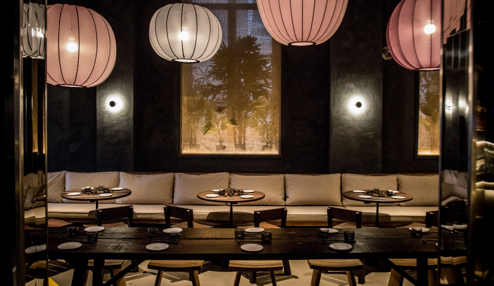 Interieur van Yuzu Dining food met tafels, stoelen en lampionnen Interieur van Yuzu Dining food met tafels, stoelen en lampionnen