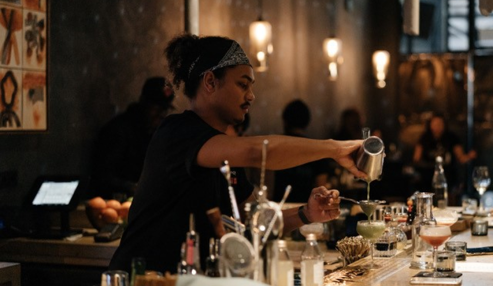 Bartender die een cocktail inschenkt