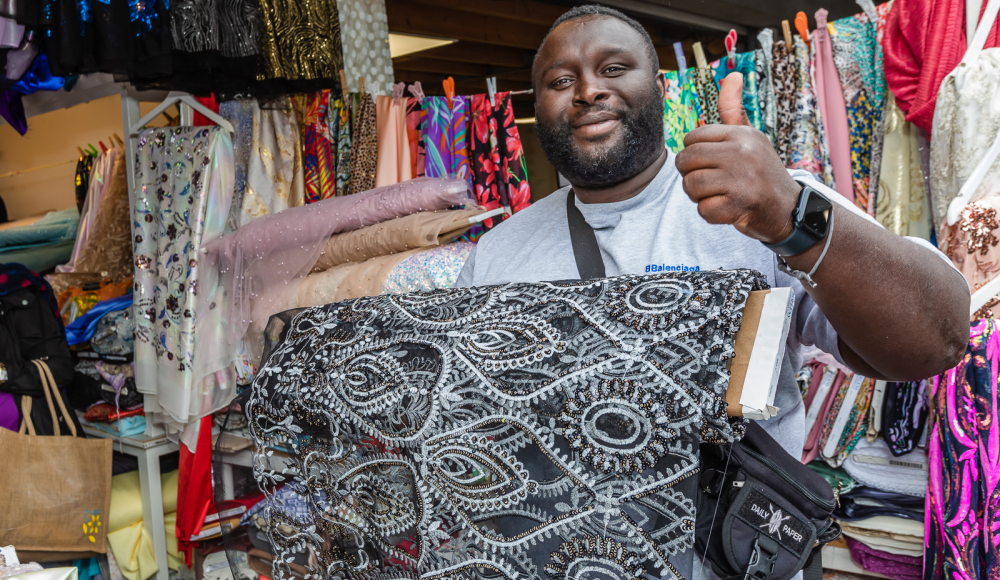 Marktverkoper met zijn stoffen op de foto