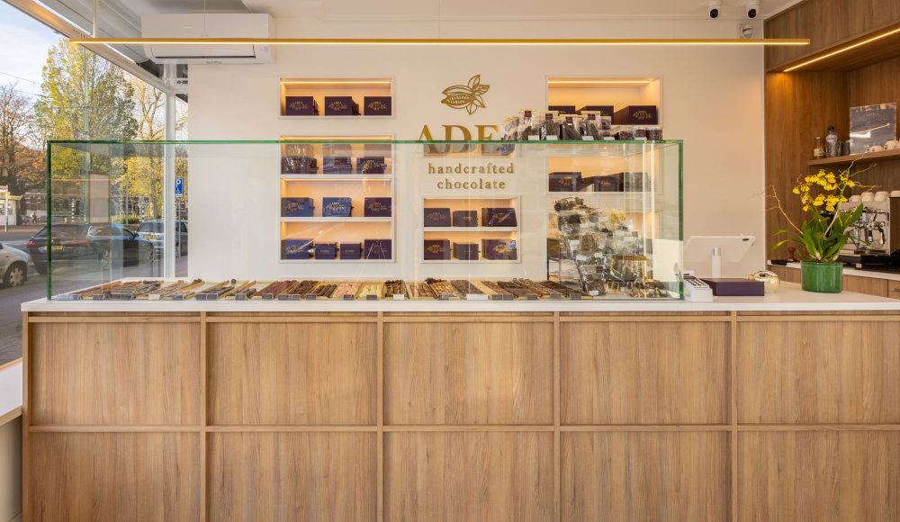  toonbank van een luxe chocoladewinkel met glazen vitrines vol chocola