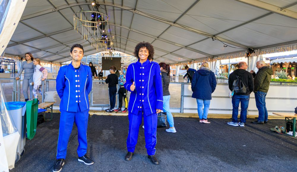 Jongens in decoratieve pakken voor winterseizoen bij Schaatsbaan in Scheveningen