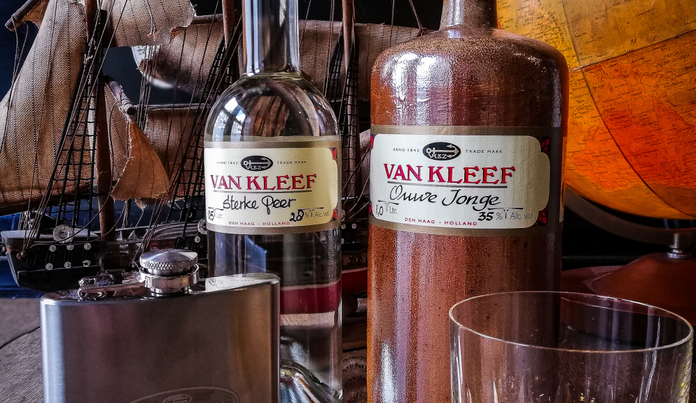 Van Kleef flessen jenever met klassiek schip en wereldbol op de achtergrond