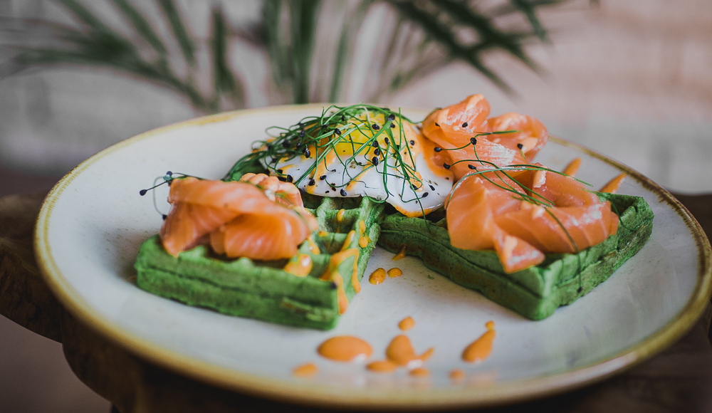 Spinaziewafel met zalm op gereserveerd op een wit bord
