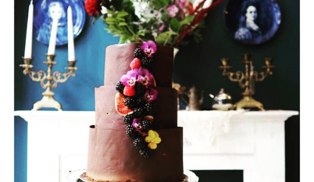 Chocolade etage taart gedecoreerd met fruit en bloemen