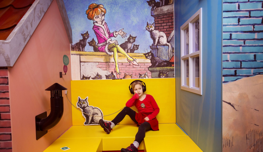 Een meisje met een koptelefoon in een kamer met poezen (c) Eveline van Egdom Een meisje met een koptelefoon in een kamer met poezen (c) Eveline van Egdom