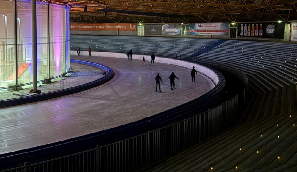 Een schaatsbaan met lichtjes op de tribune 
