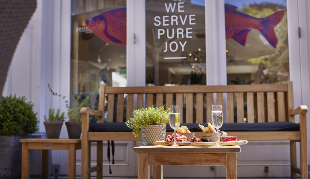 Een uitnodiging stukje terras van restaurant Sophia. Een heerlijk bankje voor een borrel in de zon. 