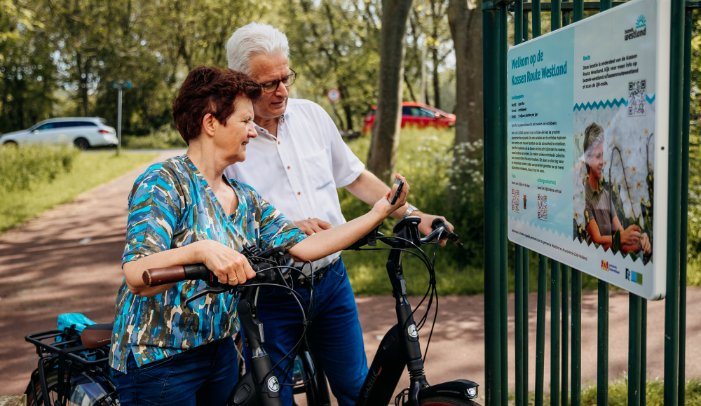 Twee mensen op de fiets die een informatiebord bekijken (c) Danja Vermeulen Twee mensen op de fiets die een informatiebord bekijken (c) Danja Vermeulen