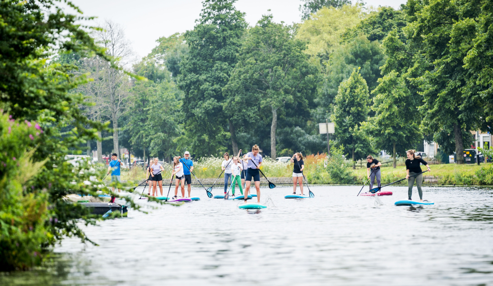 Groep mensen op SUP-boards op rustig water Groep mensen op SUP-boards op rustig water