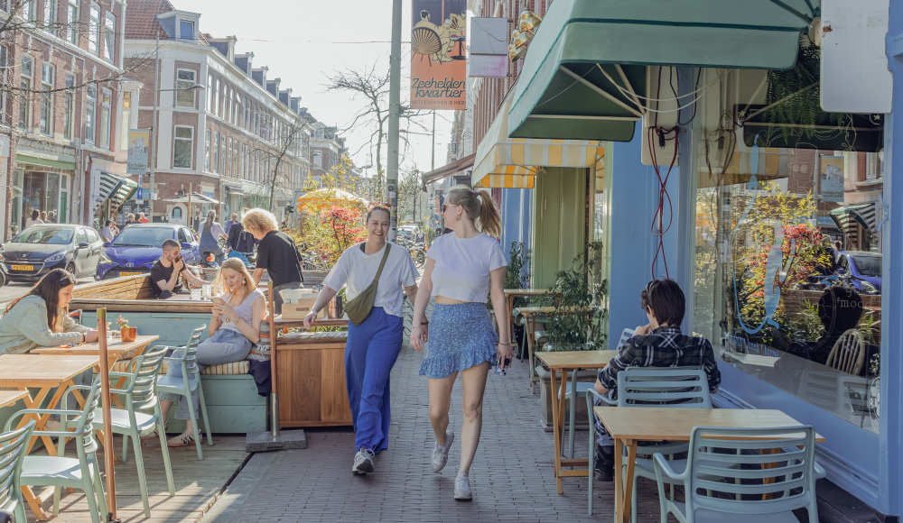 Twee dames wandelen door de Prins Hendrikstraat in Den Haag