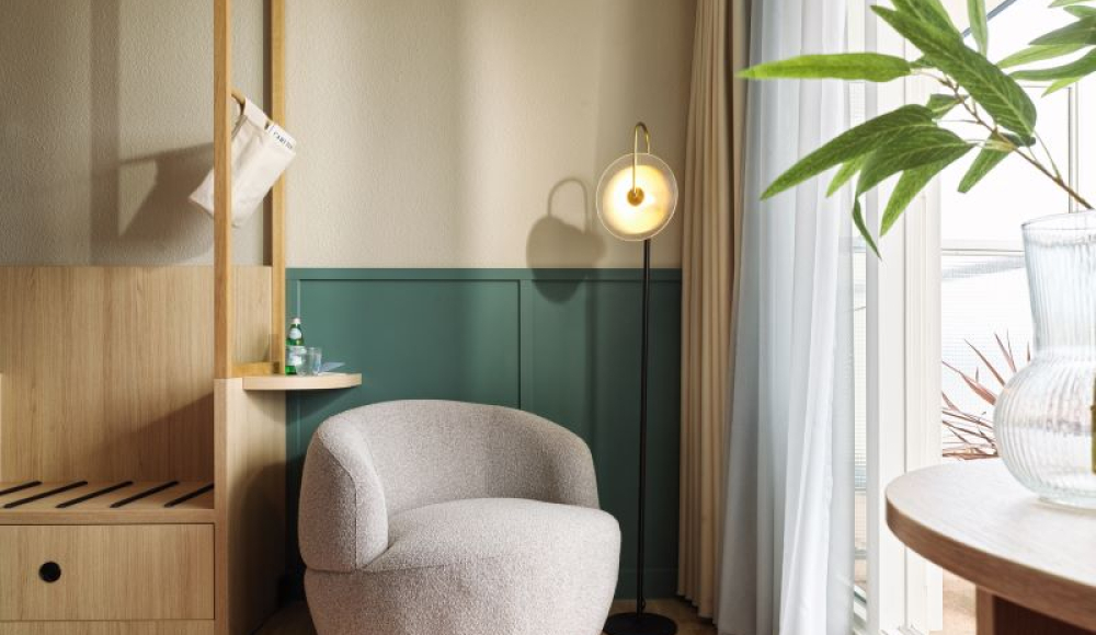 Stijlvol hoekje in een modern interieur met een ronde grijze fauteuil, staande lamp, houten accenten en zacht binnenvallend daglicht. Stijlvol hoekje in een modern interieur met een ronde grijze fauteuil, staande lamp, houten accenten en zacht binnenvallend daglicht.