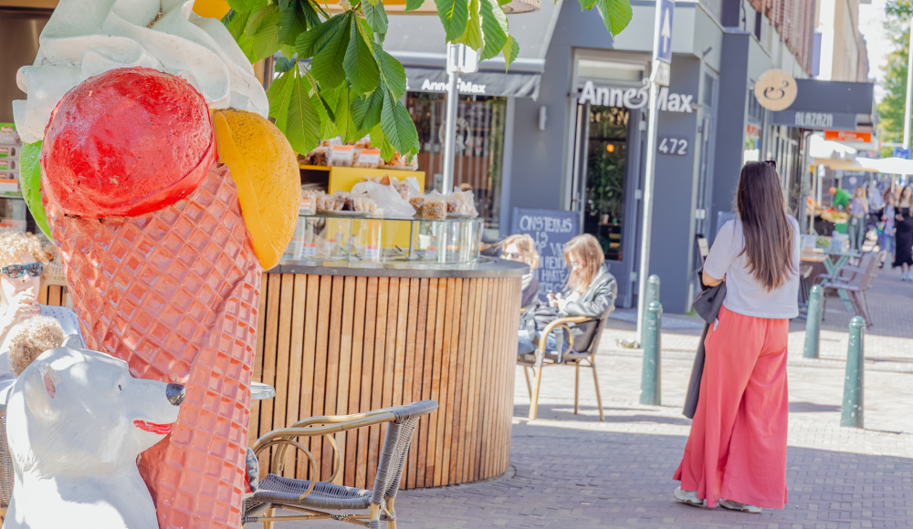 Een groot ijsje met een beer ter promotie van een ijssalon, op de achtergrond een vrouw en de Anne & Max winkel