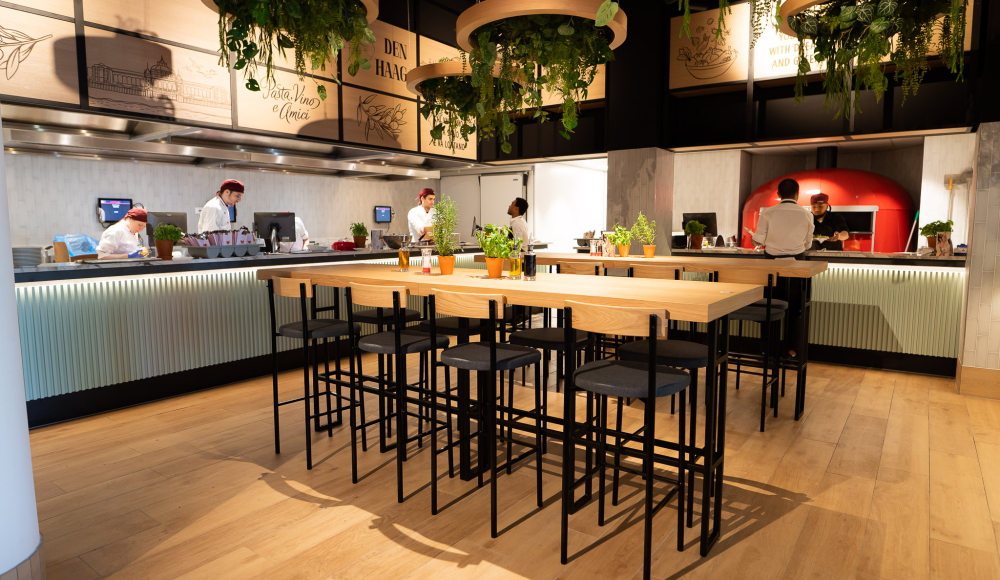 Open keuken met een moderne, frisse uitstraling waar koks live heerlijke Italiaanse gerechten bereiden. Open keuken met een moderne, frisse uitstraling waar koks live heerlijke Italiaanse gerechten bereiden.