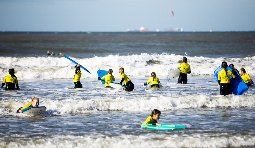 Kinderen bodyboarden in de Noordzee bij Scheveningen Kinderen bodyboarden in de Noordzee bij Scheveningen