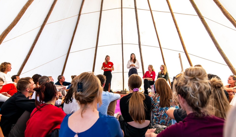 Event Impact on the Beach binnen in de tent met gastsprekers en luisterend publiek. Event Impact on the Beach binnen in de tent met gastsprekers en luisterend publiek.