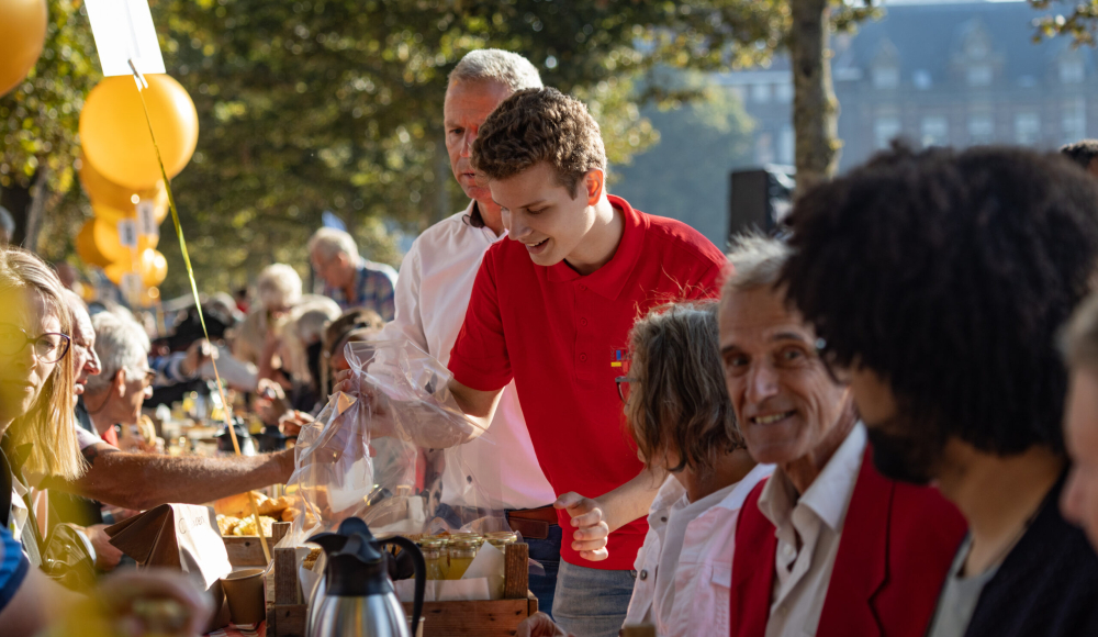 Vrijwilliger serveert ontbijt tijdens het PrinsjesOntbijt 