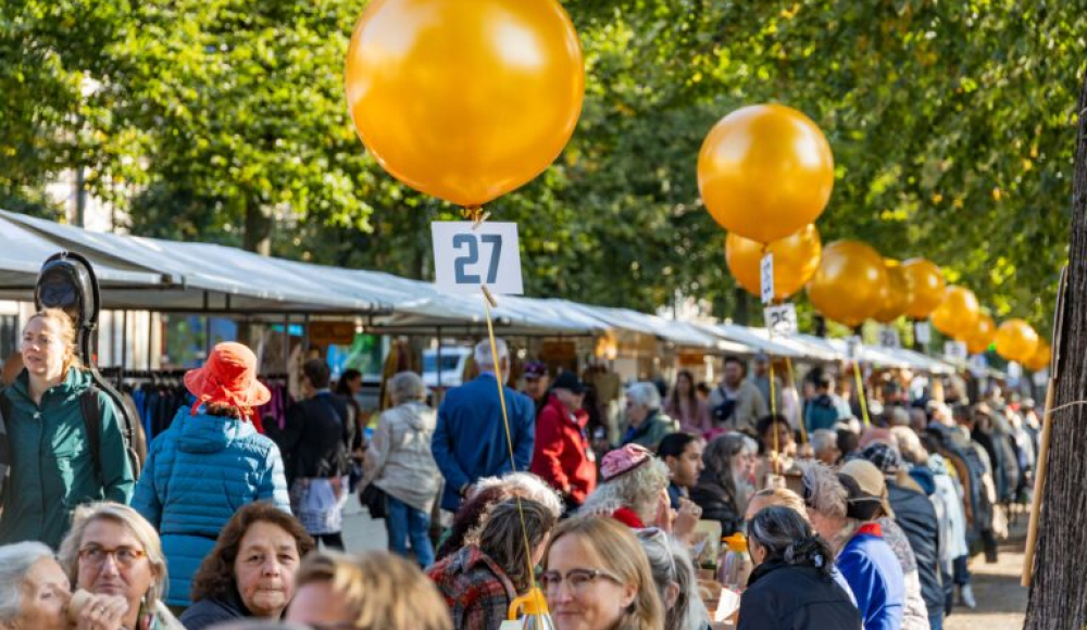 Drukke marktkramen en mensen zittend aan tafel voor het PrinsjesOntbijt
