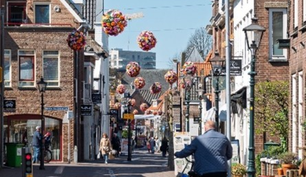 Sfeer van Dorpstraat Zoetermeer met fietser en hangende mandjes in de straat. Sfeer van Dorpstraat Zoetermeer met fietser en hangende mandjes in de straat.